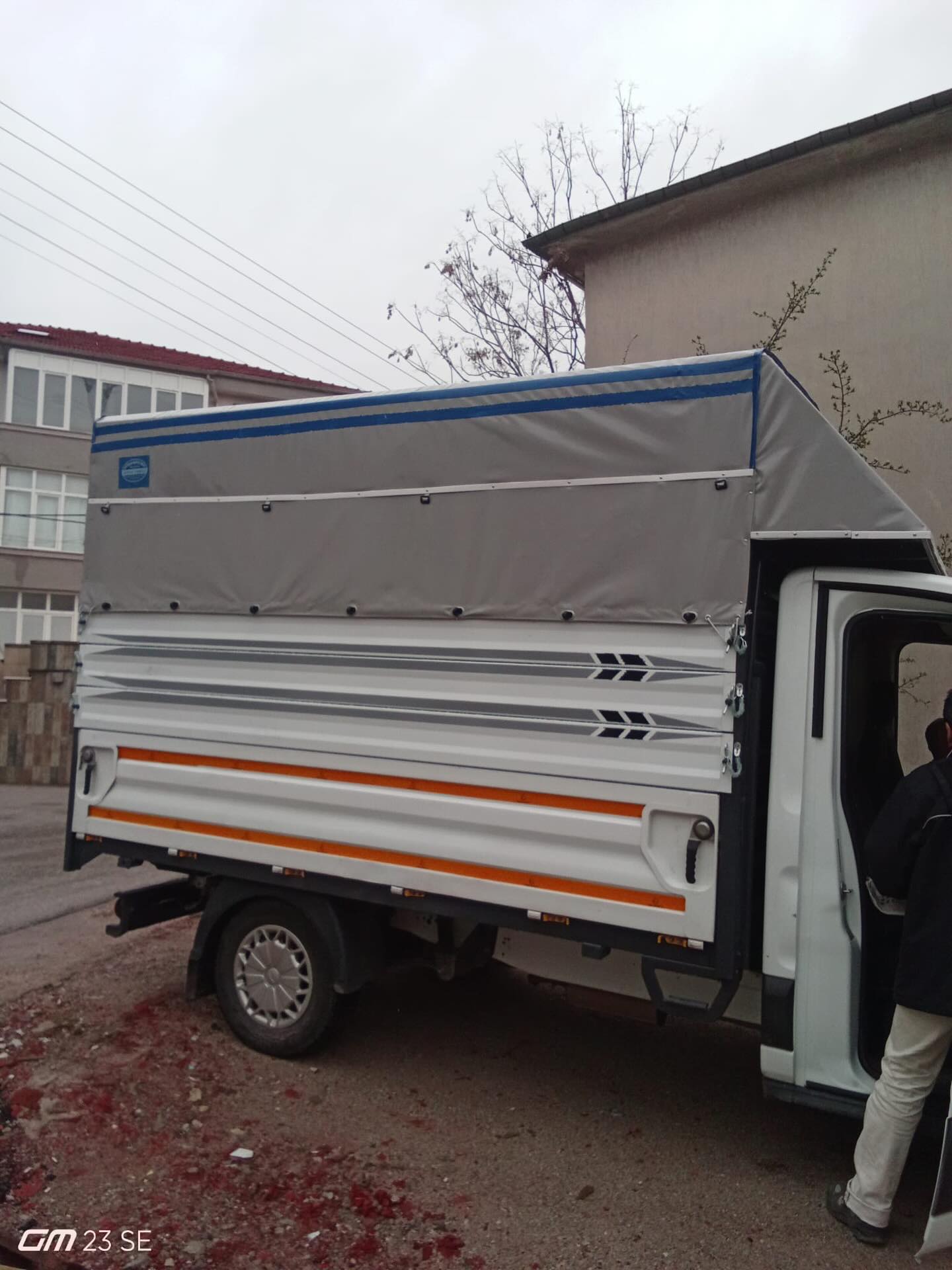 Kamyonet kasasının yan paneli, kilit kolu ve gri brandanın yandan görünümü